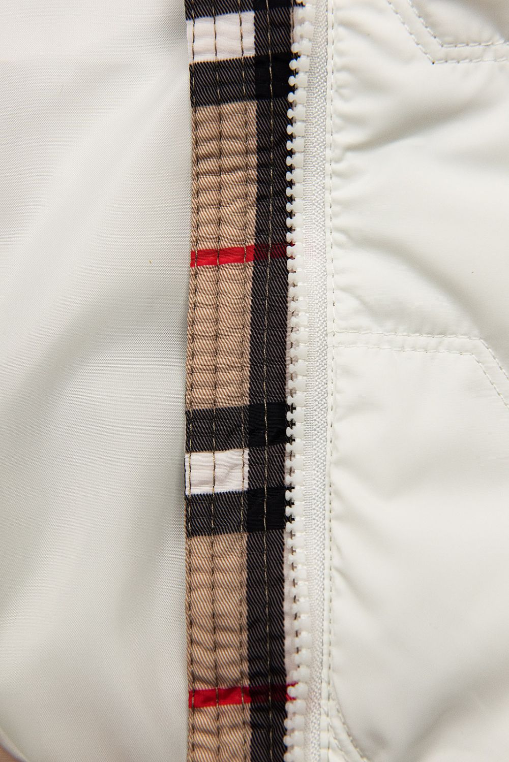 Bílá přechodná bunda s károvaným lemem